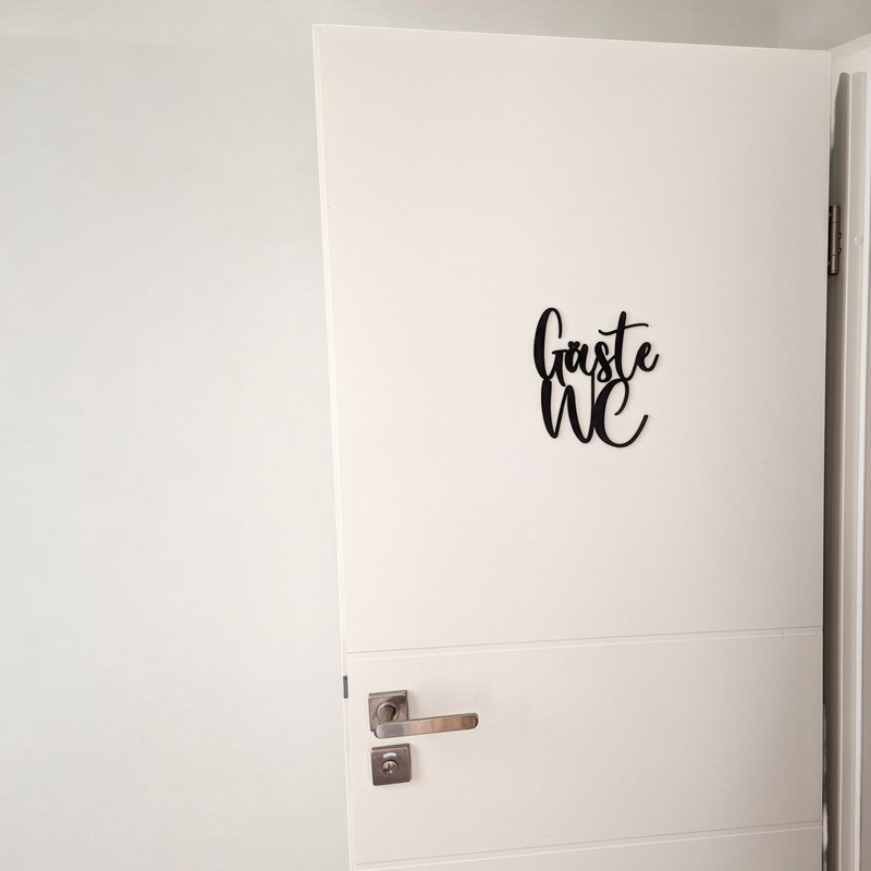 Decoración de la puerta del baño de invitados con letras.